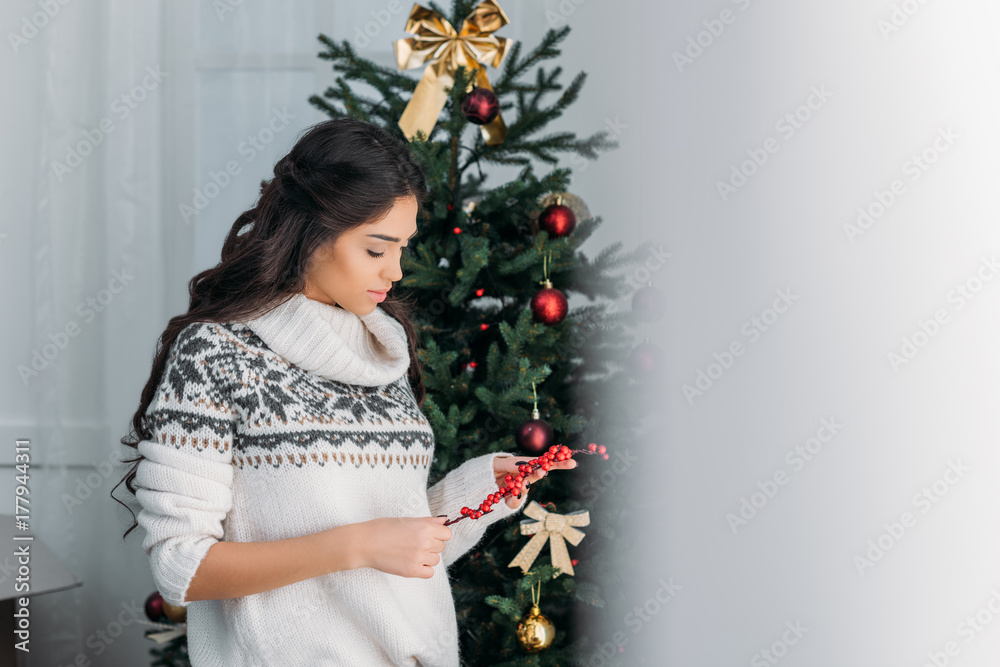 woman with branch of berries for christmas decor woman with branch of berries for christmas decor