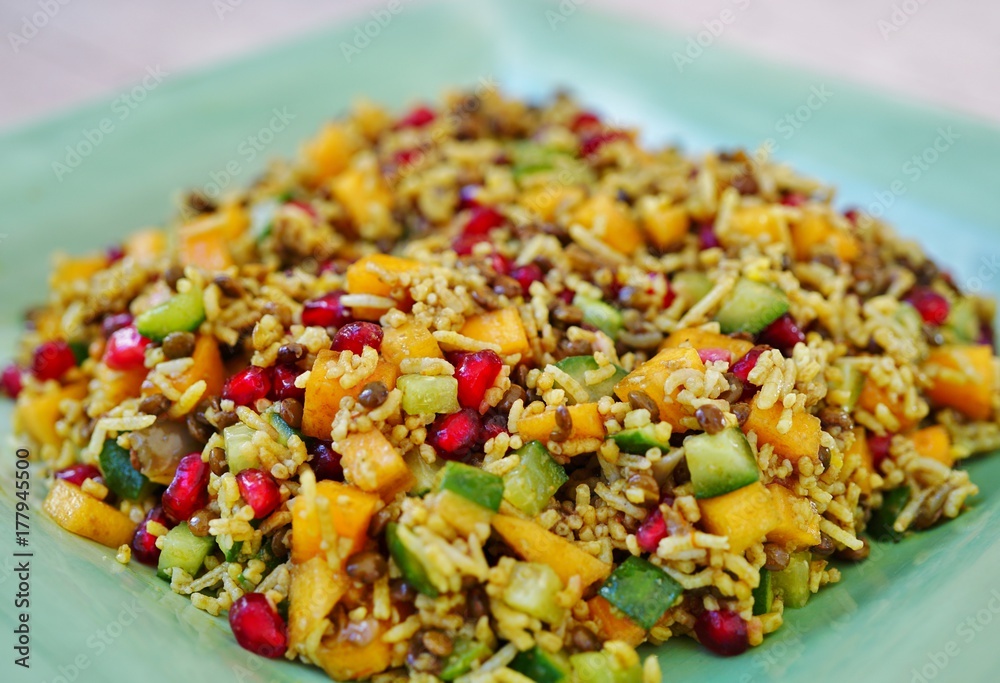 Colorful healthy vegan winter salad with rice, pomegranate seeds, persimmons and cucumber Colorful healthy vegan winter salad with rice, pomegranate seeds, persimmons and cucumber