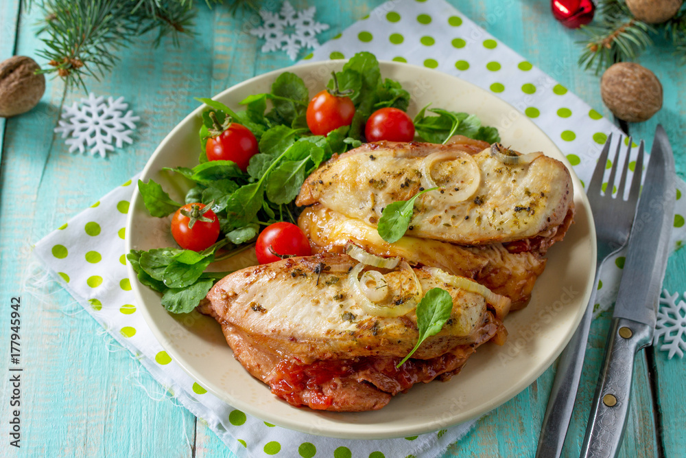 Baked chicken meat stuffed with tomatoes and cheese on a festive Christmas table.