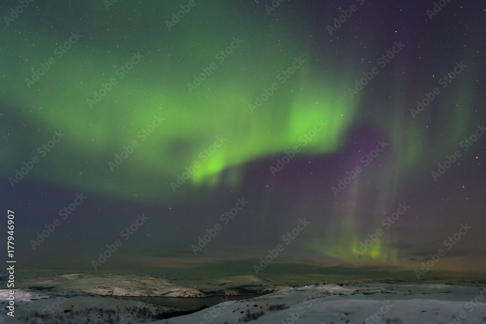 Snow covered the hills and in the sky stars, clouds and northern lights.