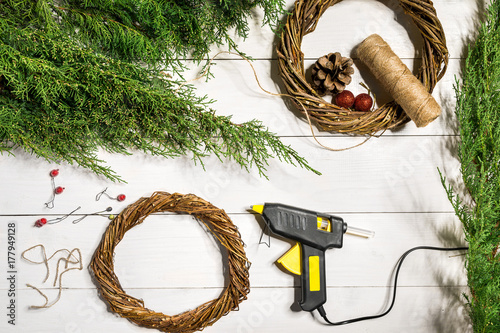 Make a Christmas wreath with your own hands. Spruce branch, Christmas wreath and gifts on a white wooden background photo