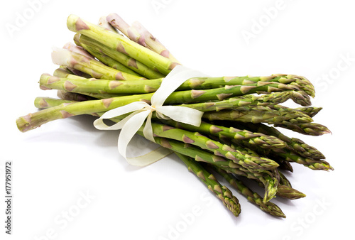 Bunch of raw asparagus tied with a creamy knotbow isolated on white background photo