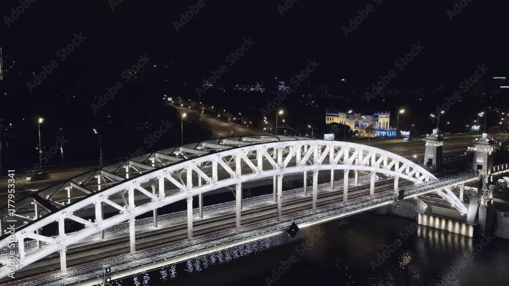 Aerial view of Luzhniki Metro Bridge, also known as Metromost, heavy traffic at night.Moscow river and city skyline during sunset. Big city life concept. Aerial view of Luzhniki Metro Bridge, also known as Metromost, heavy traffic at night.Moscow river and city skyline during sunset. Big city life concept.
