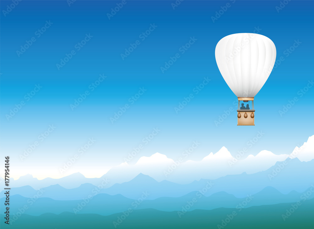 Fototapeta Balon na ogrzane powietrze dryfujący przez mglisty niebieski górski krajobraz - biały latający pojazd z dwoma pasażerami cieszącymi się wolnością, wspaniałym widokiem i mistyczną panoramą.