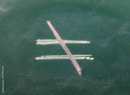 Foto Unequal symbol, sign on chalkboard, blackboard texture