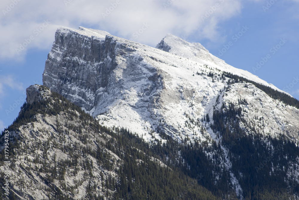 On a fall day, a light layer of snow covers Mount Rundle in Banff National Park, Alberta, Canada.