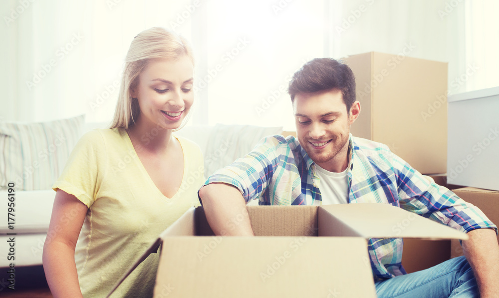 smiling couple with big boxes moving to new home smiling couple with big boxes moving to new home