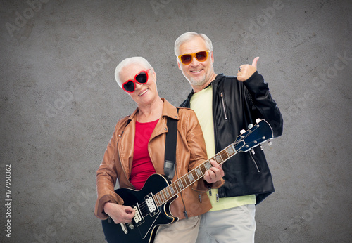 happy senior couple with guitar showing thumbs up