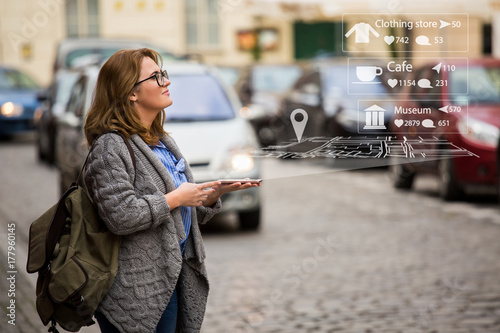 Augmented reality in marketing. Woman traveler with phone. Navigation on the projection of the display
