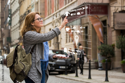 Augmented reality in marketing. Woman traveler with phone. Navigation on the projection of the display photo
