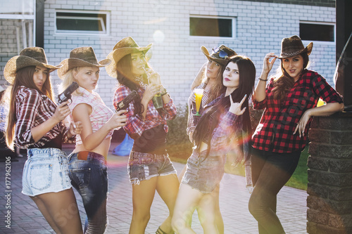 Photography Women young beautiful sensual fun at a party with drinks together in cowboy styl