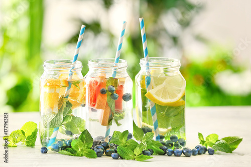 Bilde på lerret Mason jars of infused water with fruits on wooden table