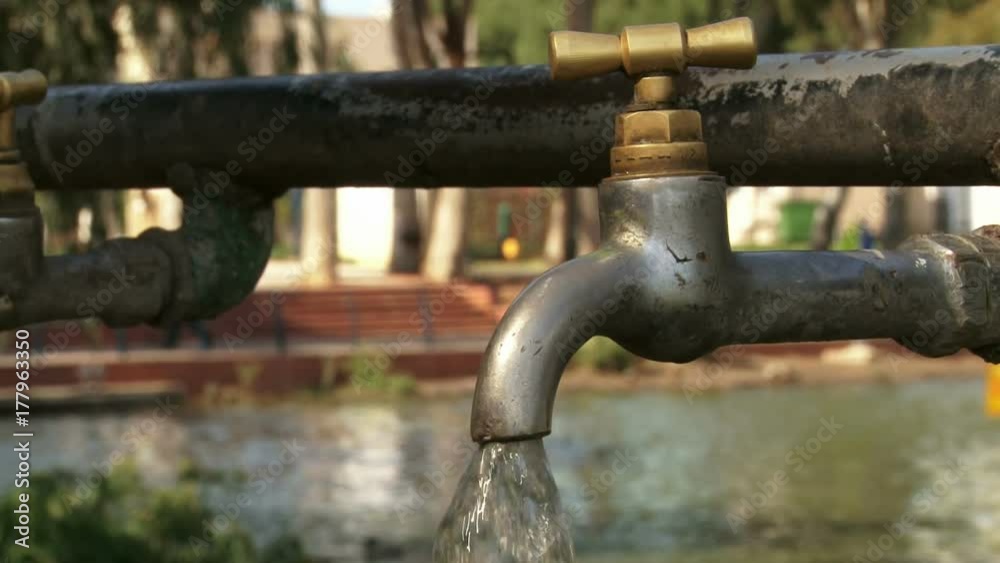 Hand opening faucet. Water flowing. Hand opening faucet. Water flowing.
