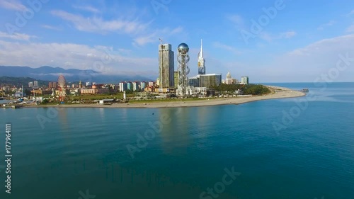 Batumi seafront park with Alphabetic Tower against cityscape, aerial zooming in photo