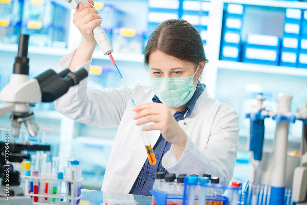 Fototapeta premium Girl laboratory assistant in the chemical laboratory of the university experiment with chemical reagents