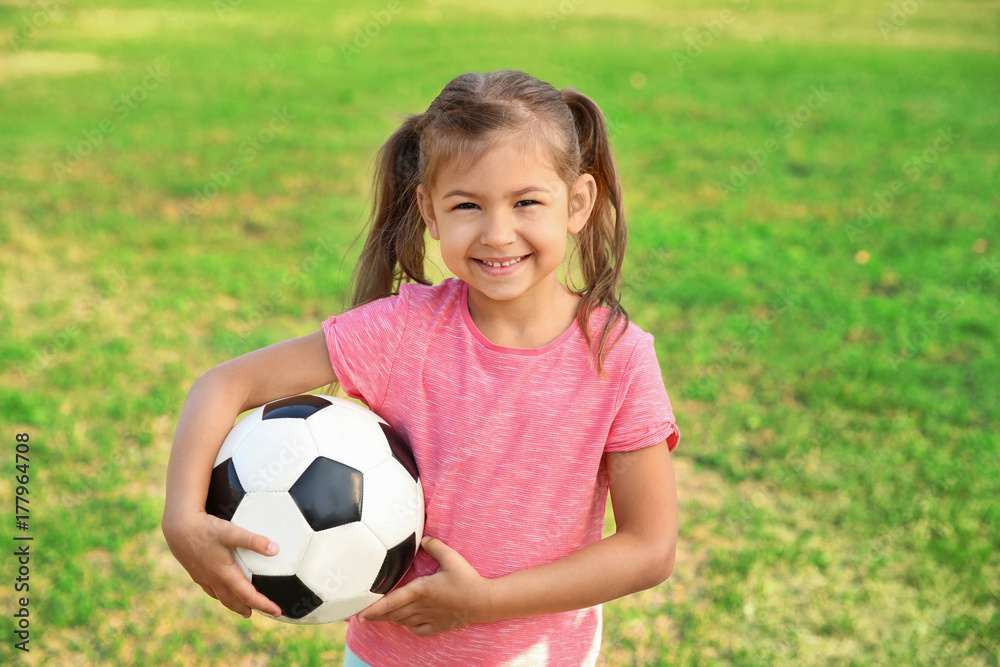 Fototapeta premium Cute little girl holding ball outdoors