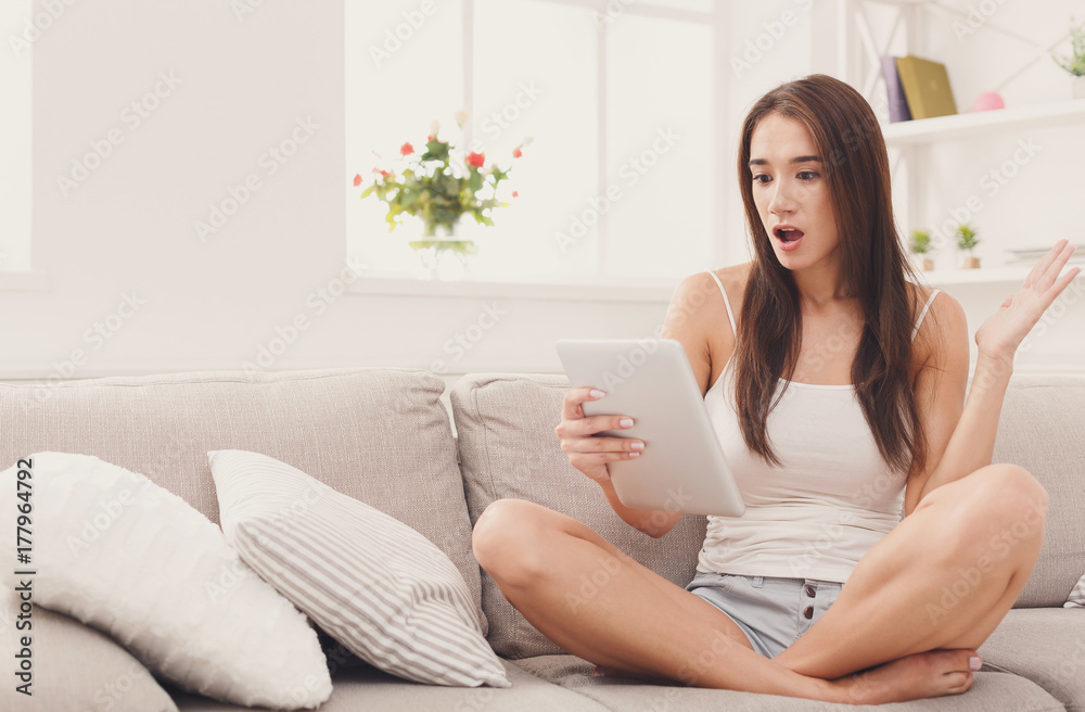 Young shocked girl with digital tablet at home Young shocked girl with digital tablet at home