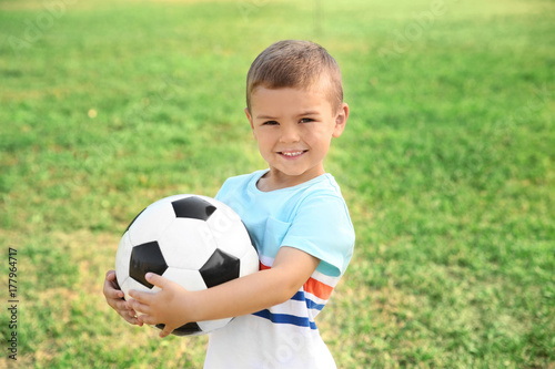 Cute little boy holding ball outdoors © Africa Studio