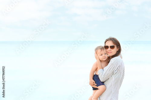 Happy mother with little son on beach © Africa Studio