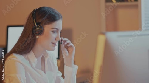 Attractive professional woman with a lovely radiant smile wearing a headset and microphone , conceptual of a receptionist, call center or public relations