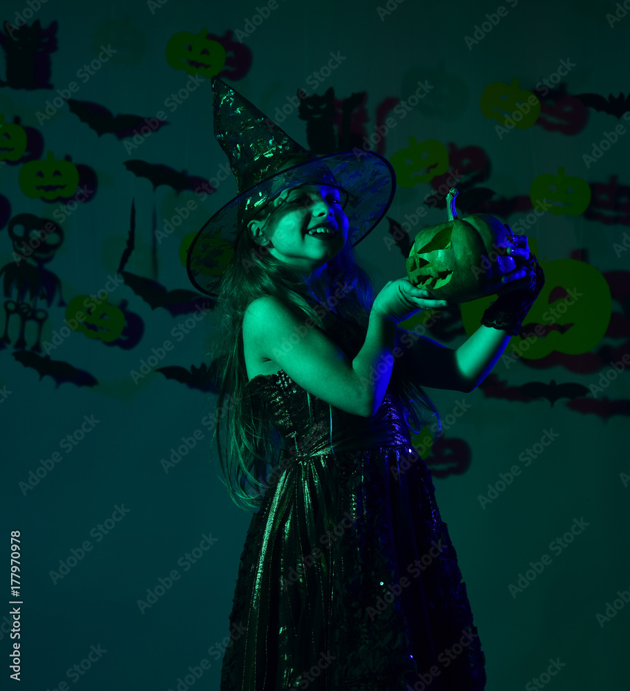 Kid in spooky witches costume holds jack o lantern Kid in spooky witches costume holds jack o lantern