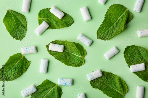 Photography Chewing gum and mint leaves on color background