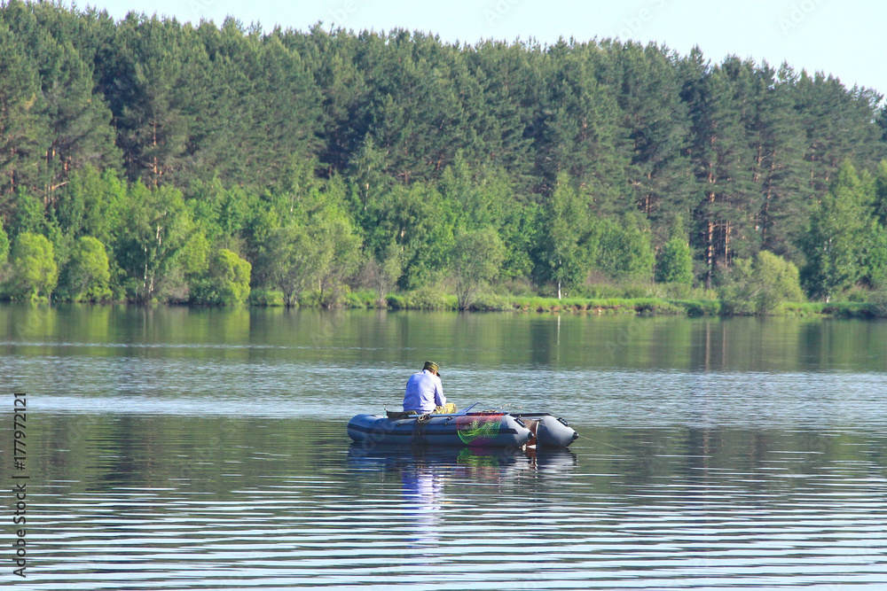man in a boat fishing on lake