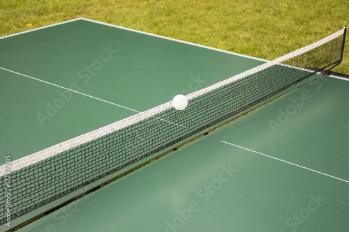 Table tennis, ping-pong table and the white ball on a green table.