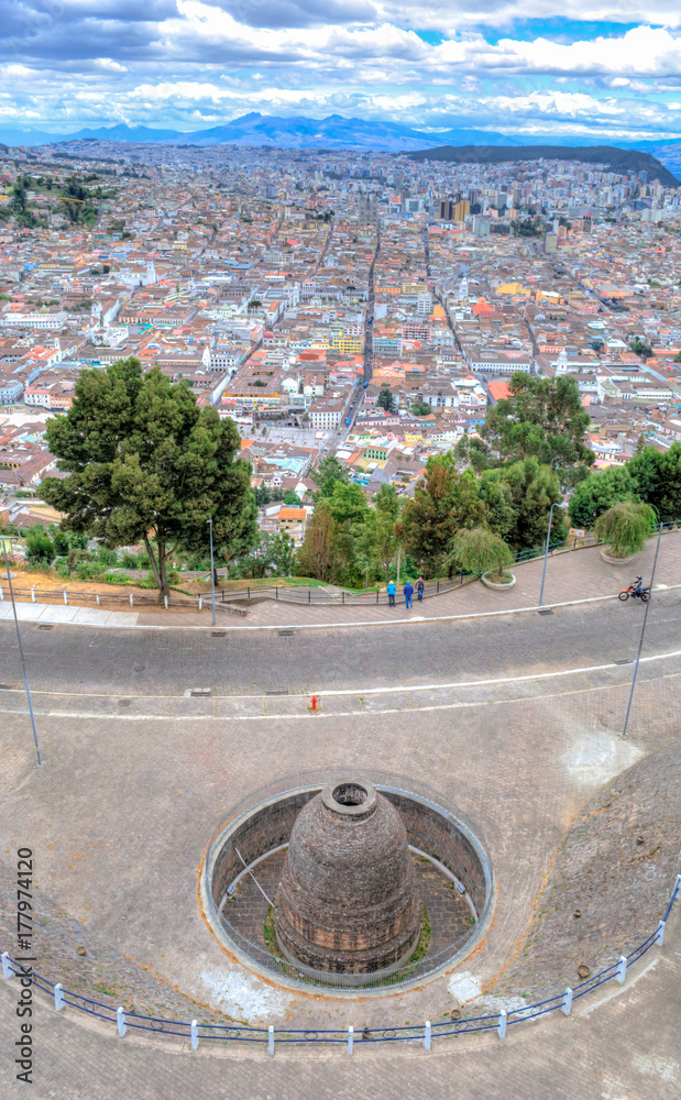 View of Quito and an archeological ruin at the Panecillo hill, on an overcast and cloudy afternoon. Quito, Ecuador.