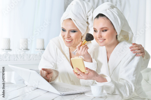 young women in bathrobes with laptop