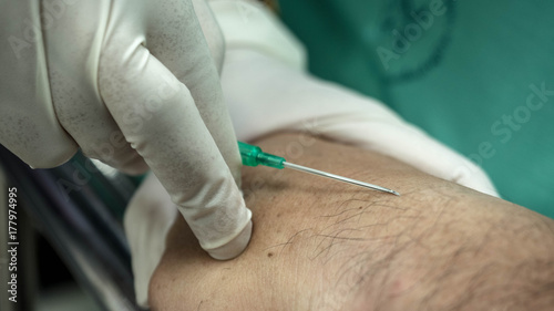 Blood collection, taking a blood sample from the patient's arm.