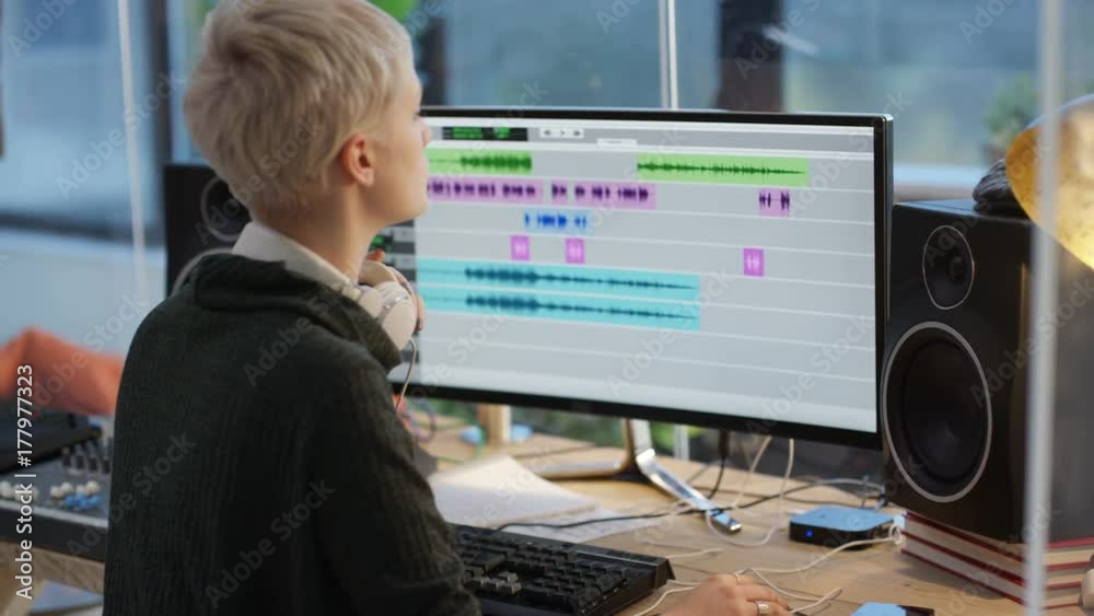 Sound engineer at mixing desk recording a track with young musicians Sound engineer at mixing desk recording a track with young musicians