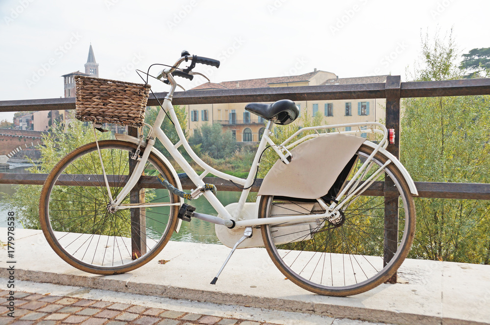 A bicycle is parked in a beautiful city. Bicycle on the background of the cityscape.