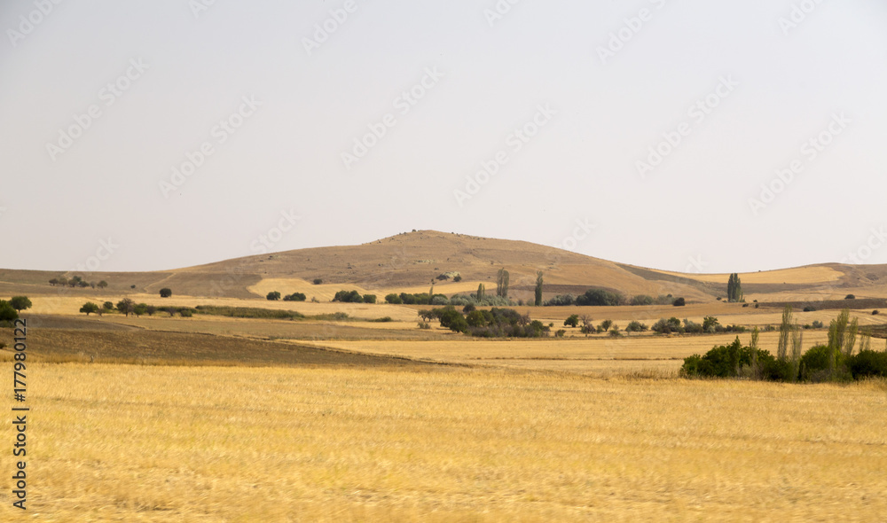 View of flat lands and small hills of the Central Anatolian geography from the road. Central Anatolia has arid climate with hot summers and extremely cold winters.