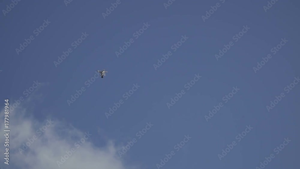 Flying drone in blue sky Flying drone in blue sky