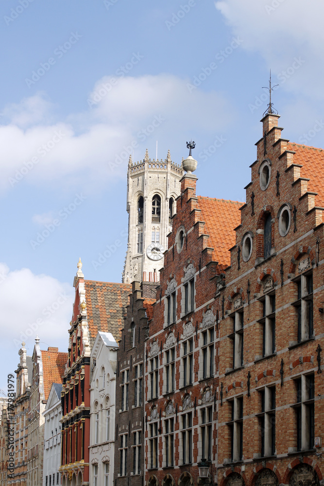 Ancient houses and a tower. The medieval architecture of Bruges.