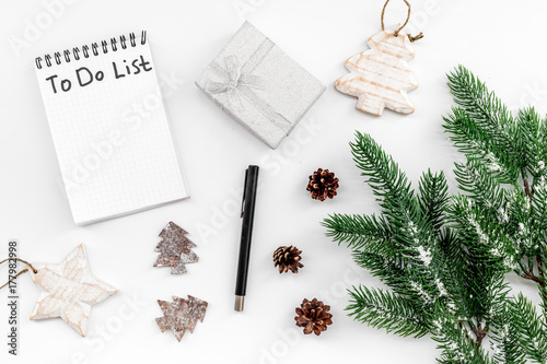 Make to do list for new year. Notebook among new year decorations on white background top view