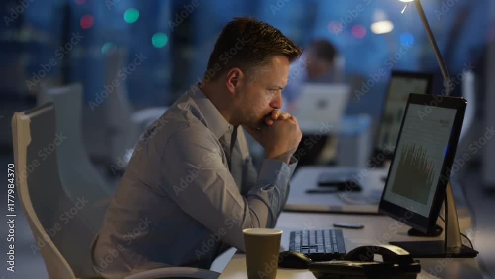  Exhausted businessman working late at the office