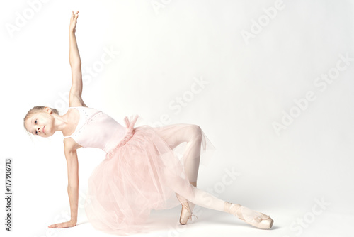 Photo A little ballerina in a pink tutu performs a pas