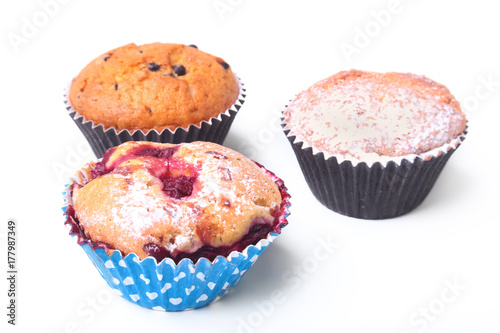 Homemade Blueberry and chocolate muffins with powdered sugar and fresh berries.