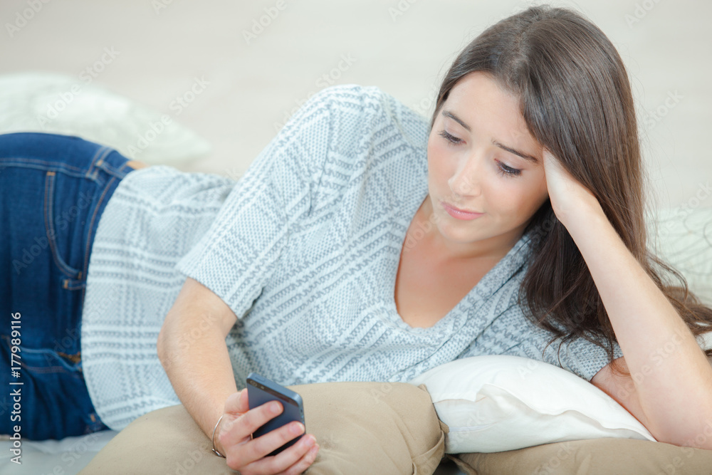 Sending a text message whilst laying on a sofa Sending a text message whilst laying on a sofa