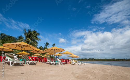 Vacation concept - Beach chairs and umbrellas on tropical beach © Gustavo