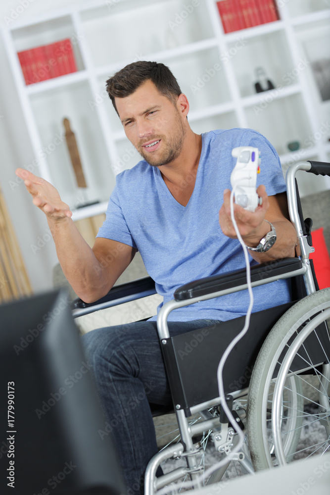 disabled man on the wheelchair holding a joystick disabled man on the wheelchair holding a joystick
