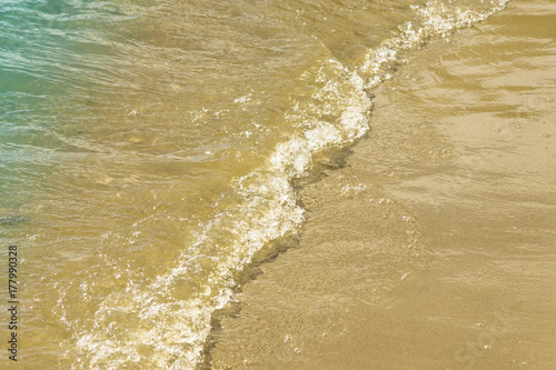 Soft waves on a sandy seashore. Sea beach on a sunny day.