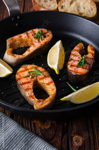 Grilled salmon steaks in cast iron pan.