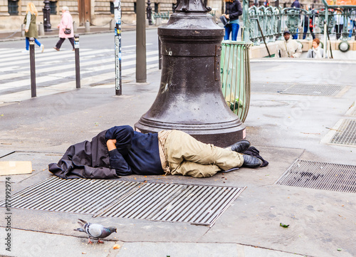 Canvas Print The homeless clochard sleeps right on the street near Louvre