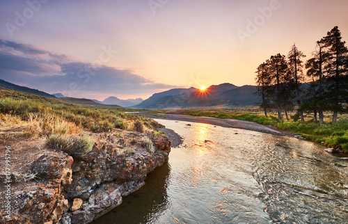 Soda Butte Creek catches sun's first light - Rocky banks on one side and sagebrush flats on the other bank photo