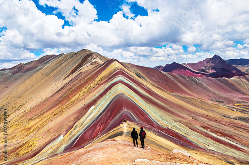 Tourists couple stand and look afar at Rainbow Mountains, Cusco, Peru