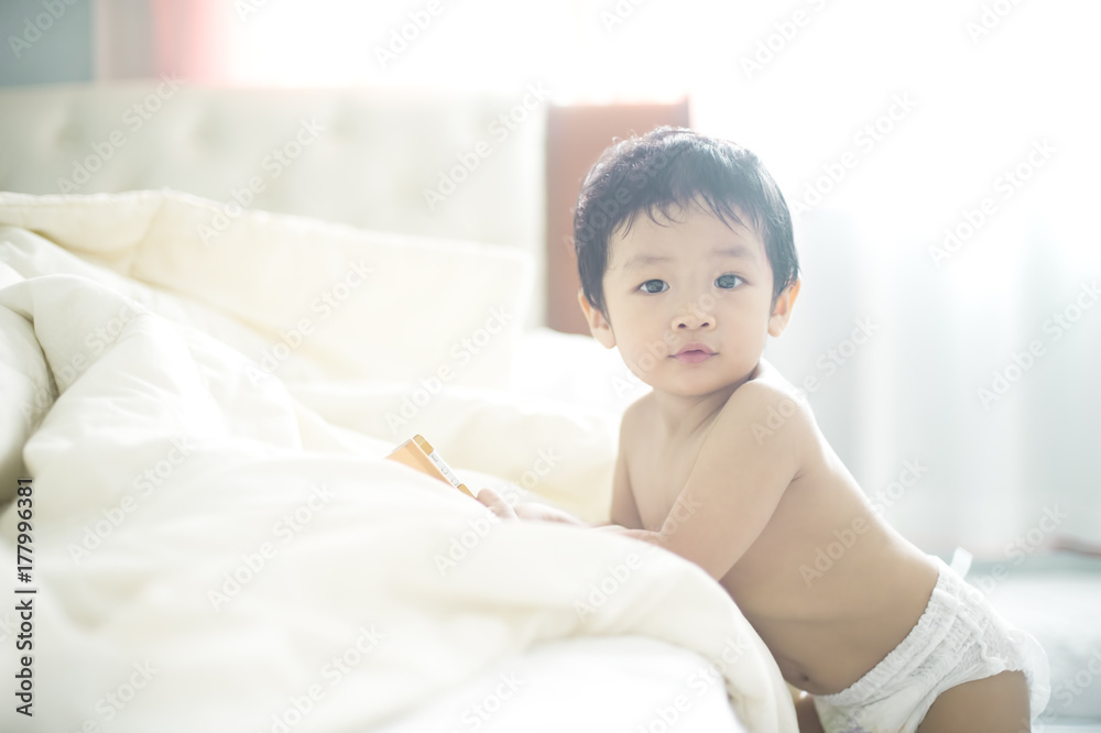 Baby holding smartphone looking at camera