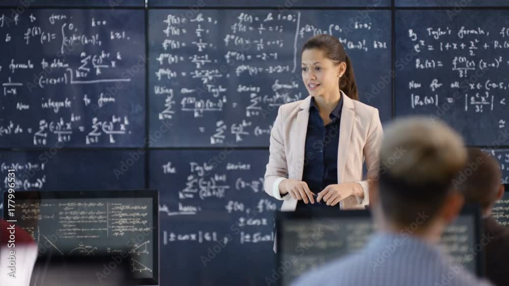 Teacher in adult education class explaining math formulas to students Teacher in adult education class explaining math formulas to students